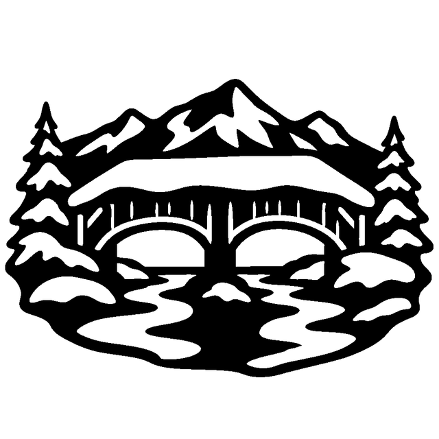 Snow-covered covered bridge over a winding river, framed by pine trees and jagged mountain peaks.